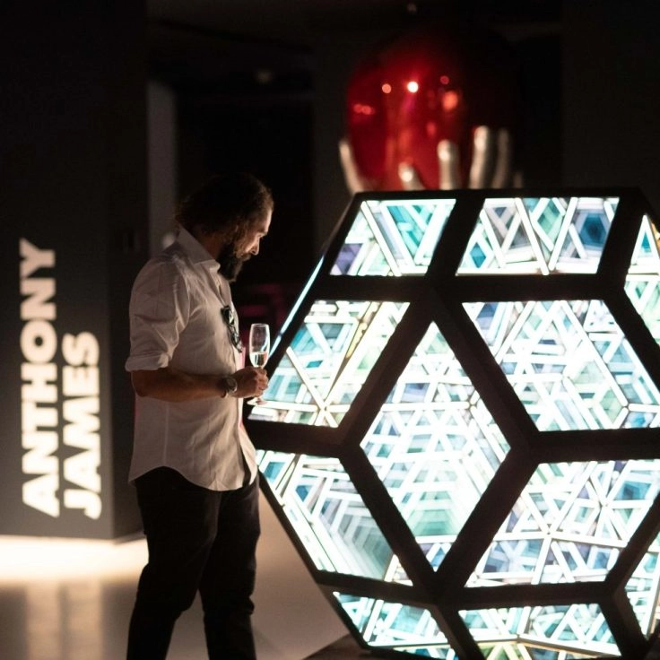 Visitors viewing mirrored hexagonal installation by Anthony James at Moco Museum London.
